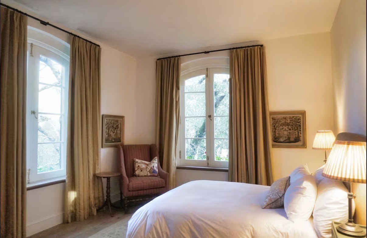 Bedroom with arched windows and gold curtains